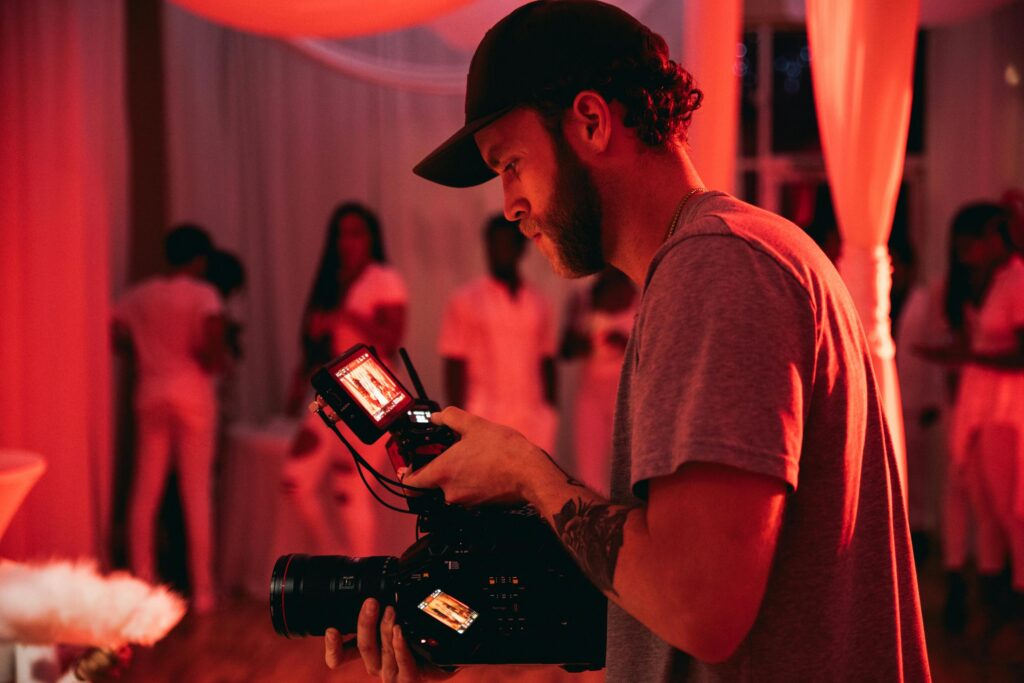 A cinematographer captures a scene in a vibrant indoor setting with warm lighting.
